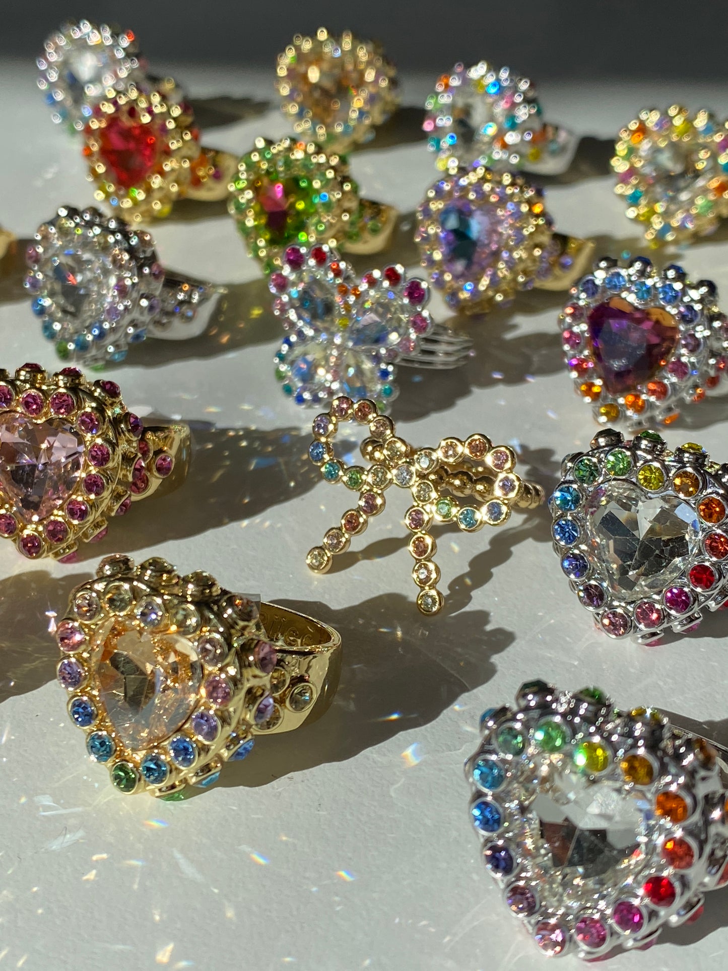 Colorful gemstone rings on a reflective surface