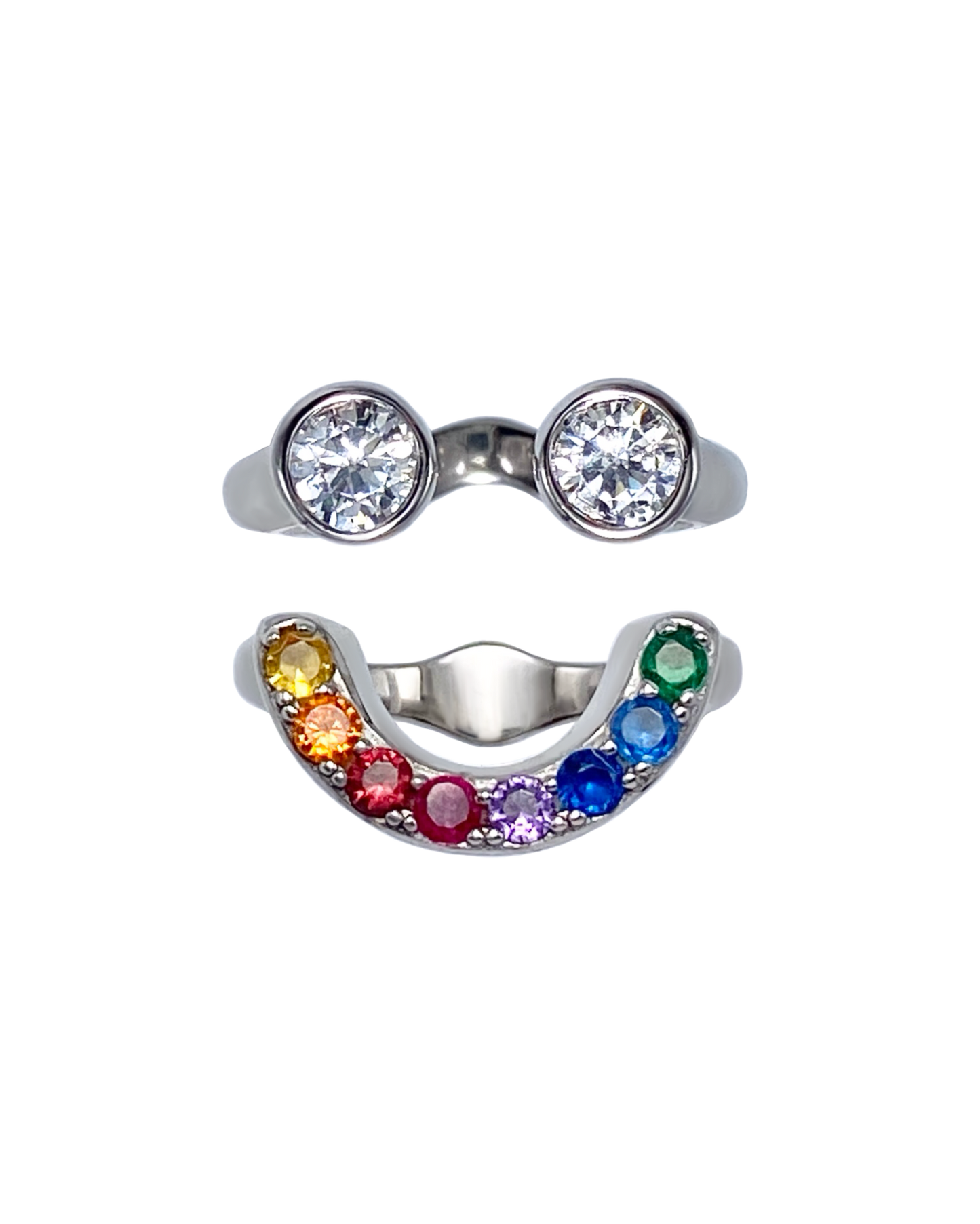 Silver ring with two large gemstones and a rainbow-colored band on a white background that forms a smiley face ring set