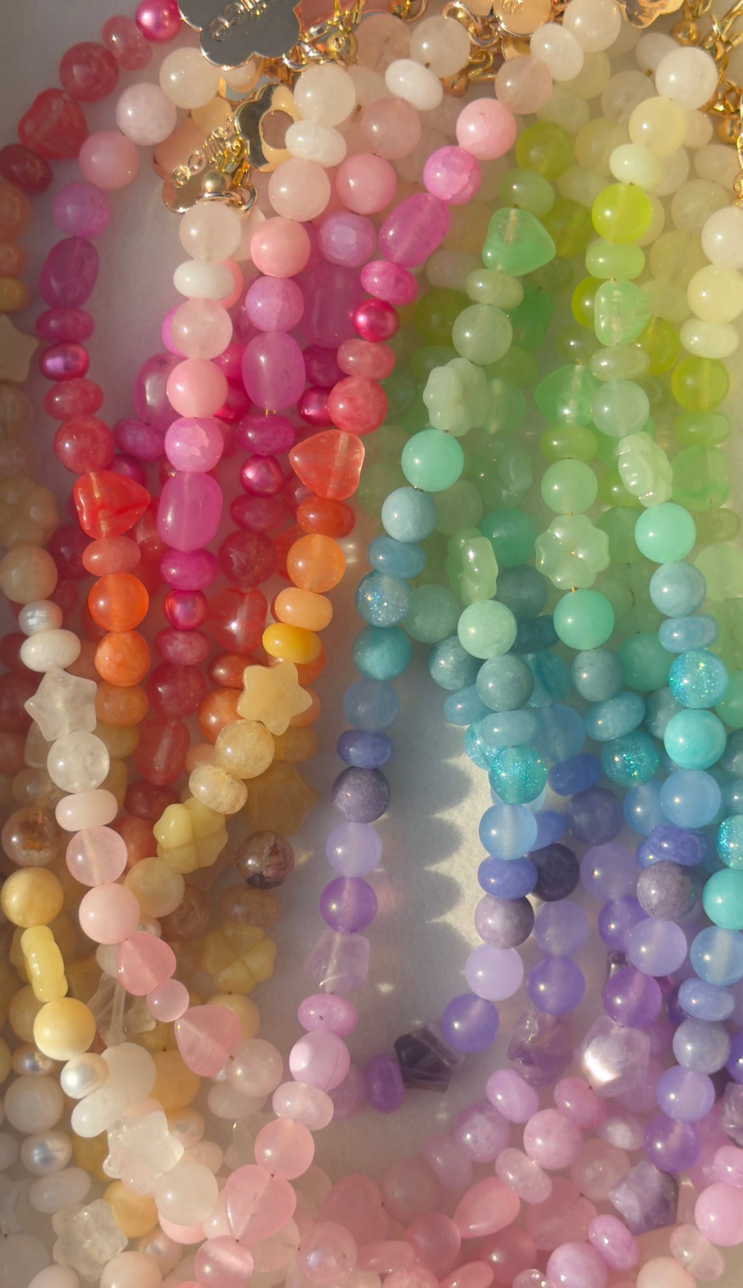 Colorful beaded necklaces arranged in a rainbow pattern.
