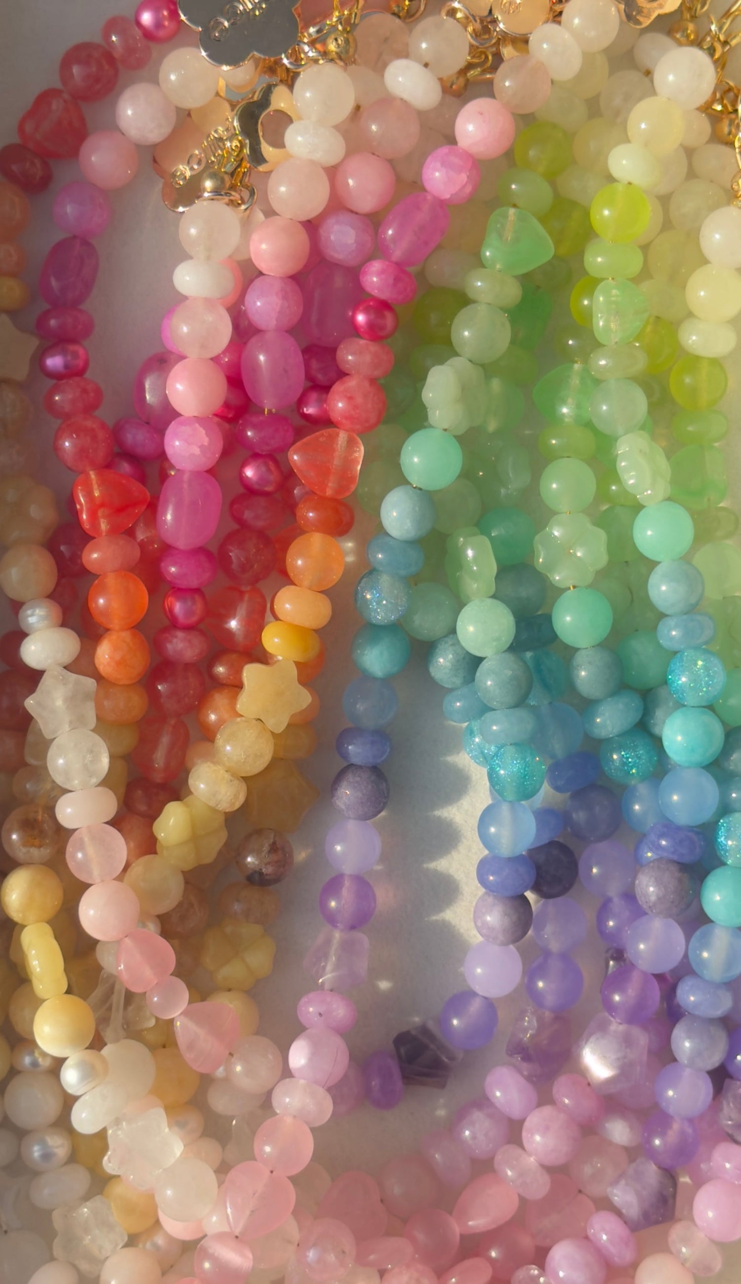 Colorful beaded necklaces arranged in a rainbow pattern.