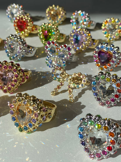 Colorful gemstone rings on a reflective surface